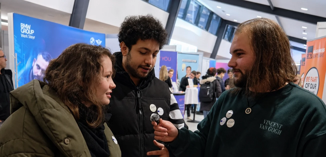 SNL members interviewing students at a fair in Linz